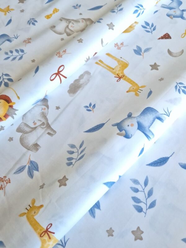 Tela sarga con estampado de jirafas y rinocerontes bebés dispuesta en forma de olas