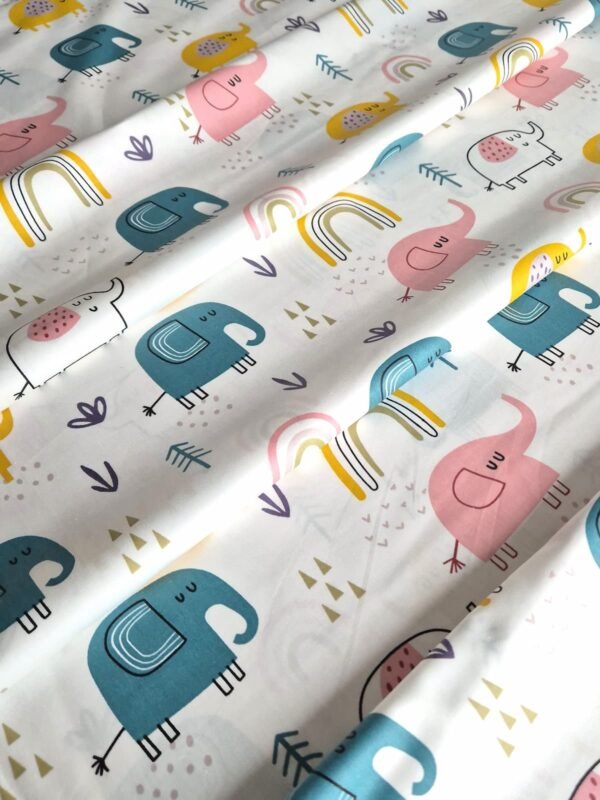 Tela sarga con estampado de elefantes y arcoíris en tono rosa dispuesta en forma de olas