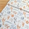 Vista diagonal de tela sarga con ilustraciones de animales de la selva como elefantes, jirafas, leones y monos sobre fondo blanco