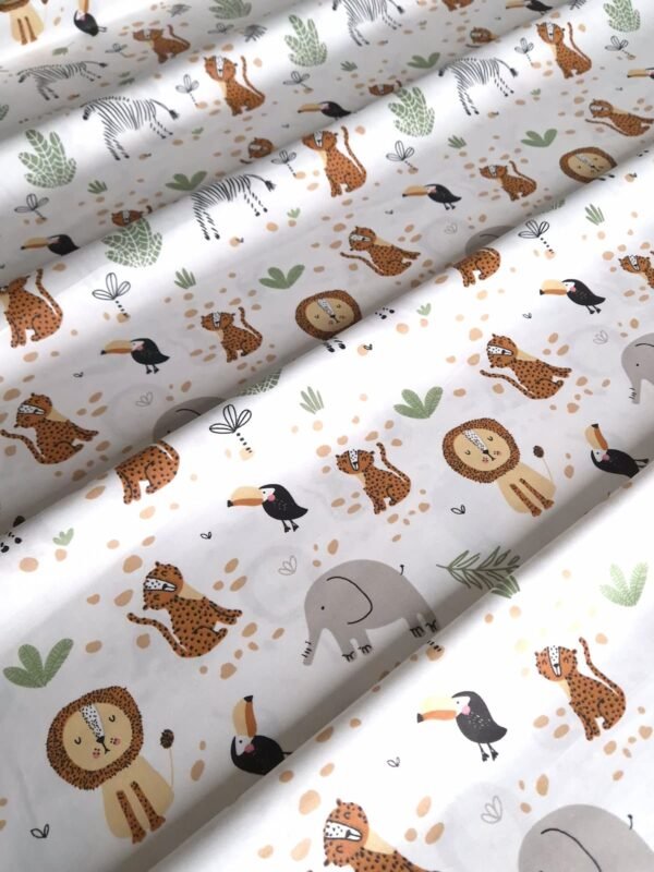 Tela sarga con estampado de leones, cebras y leopardos bebés dispuesta en forma de olas