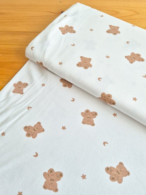 Tela interlock con estampado de ositos y lunas vista en ángulo de 45 grados