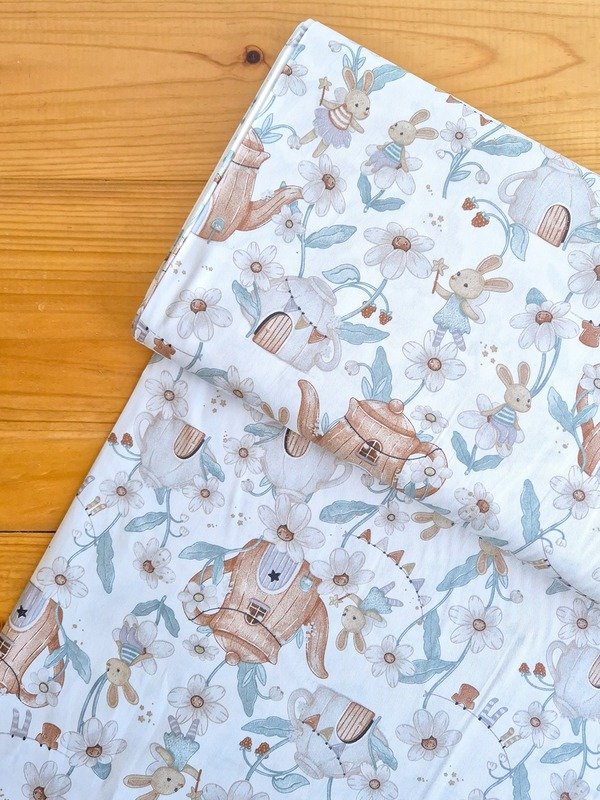 Tela sarga (tela crea), tela de algodón con estampado infantil de conejos hada, casas en forma de tetera y flores para confección y manualidades en Chile