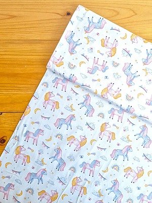 Tela sarga (tela crea), tela de algodón con estampado de unicornios, arcoíris y nubes en tonos rosados para confección y manualidades en Chile