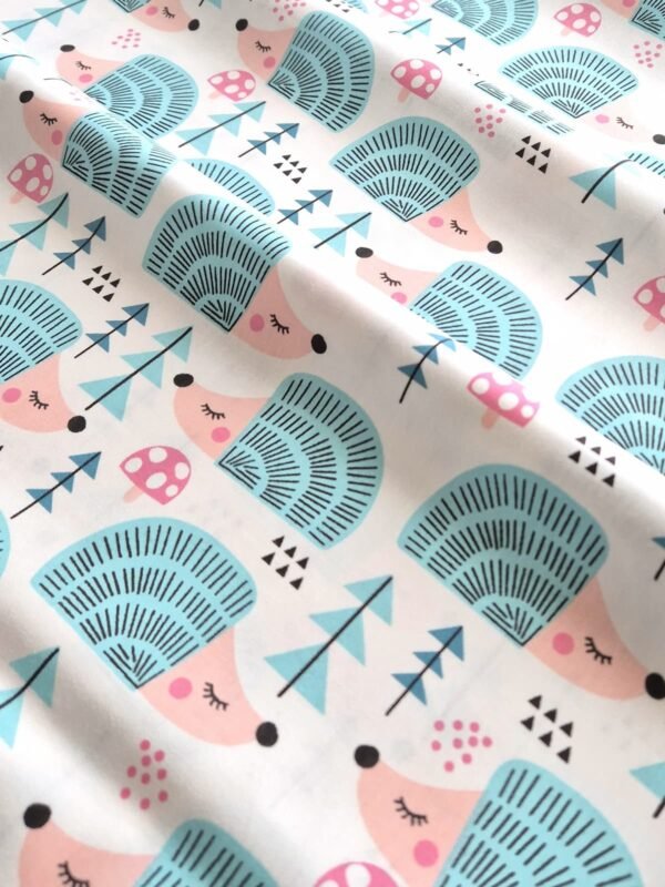 Tela sarga con estampado de erizo con setas y pinos dispuesta en forma de olas