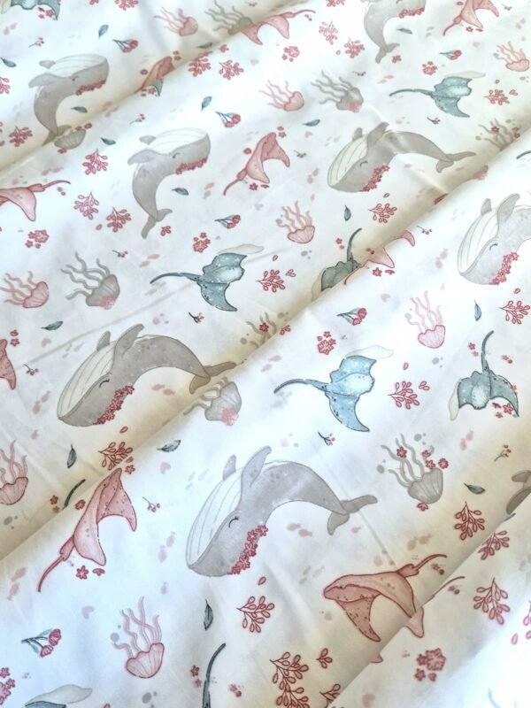 Tela sarga con estampado de vida marina en tonos pastel dispuesta en forma de olas