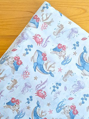 Tela sarga con estampado de animales marinos y flores vista desde arriba